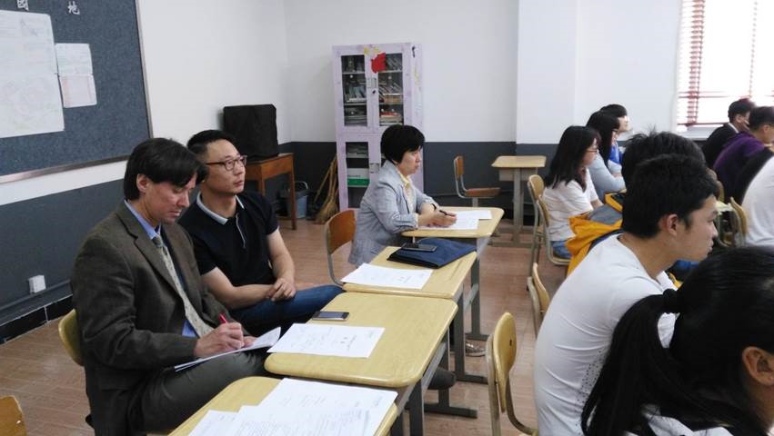 Hora observes a biology class with help from his translator, Liming Wen, an English teacher at the college.