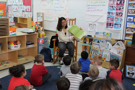 Capital High student Mitzy Magallan reads to Orchard Ridge Elementary School students for a district event.