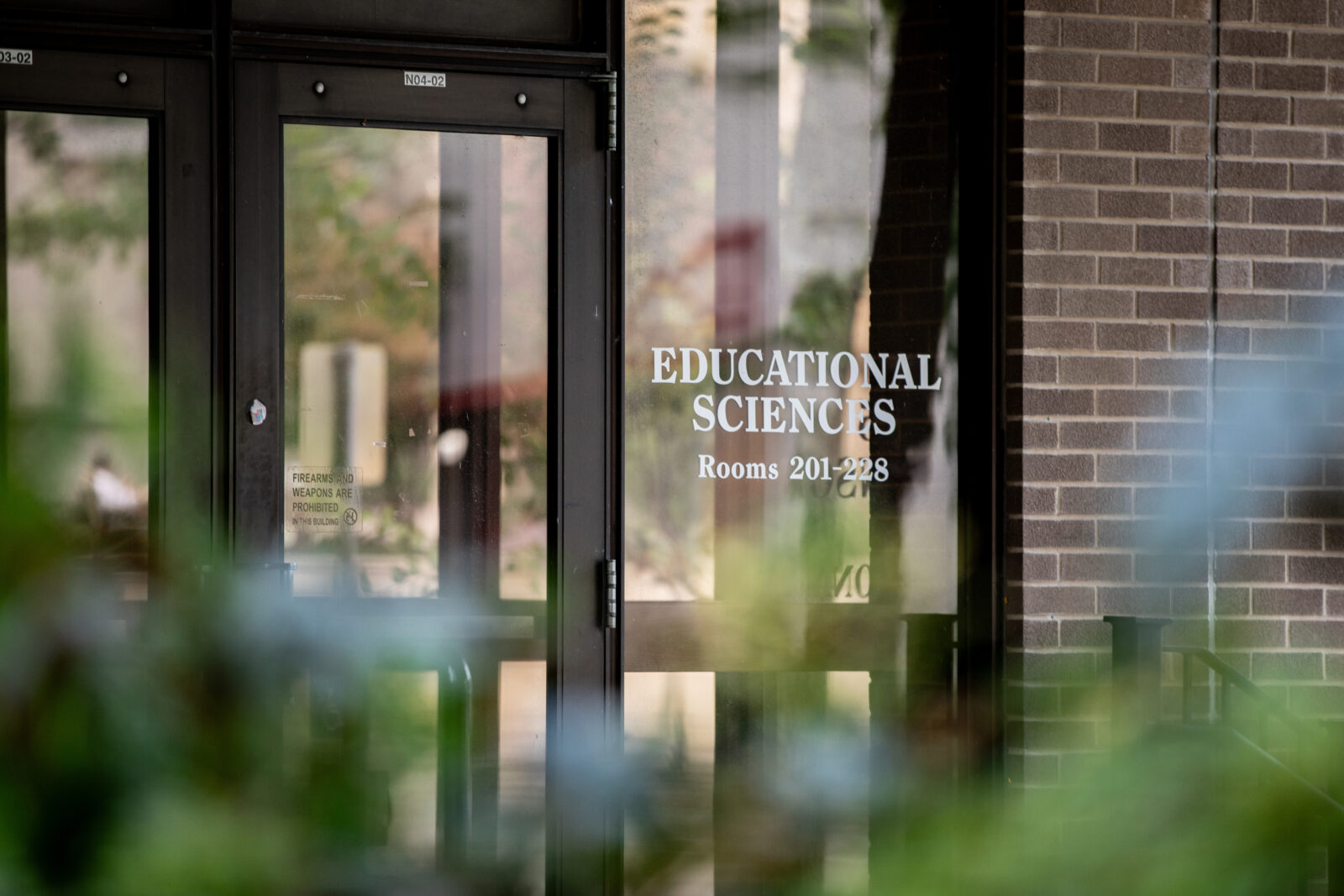 The front doors of the Educational Science Building with the building's title shown on the windows.