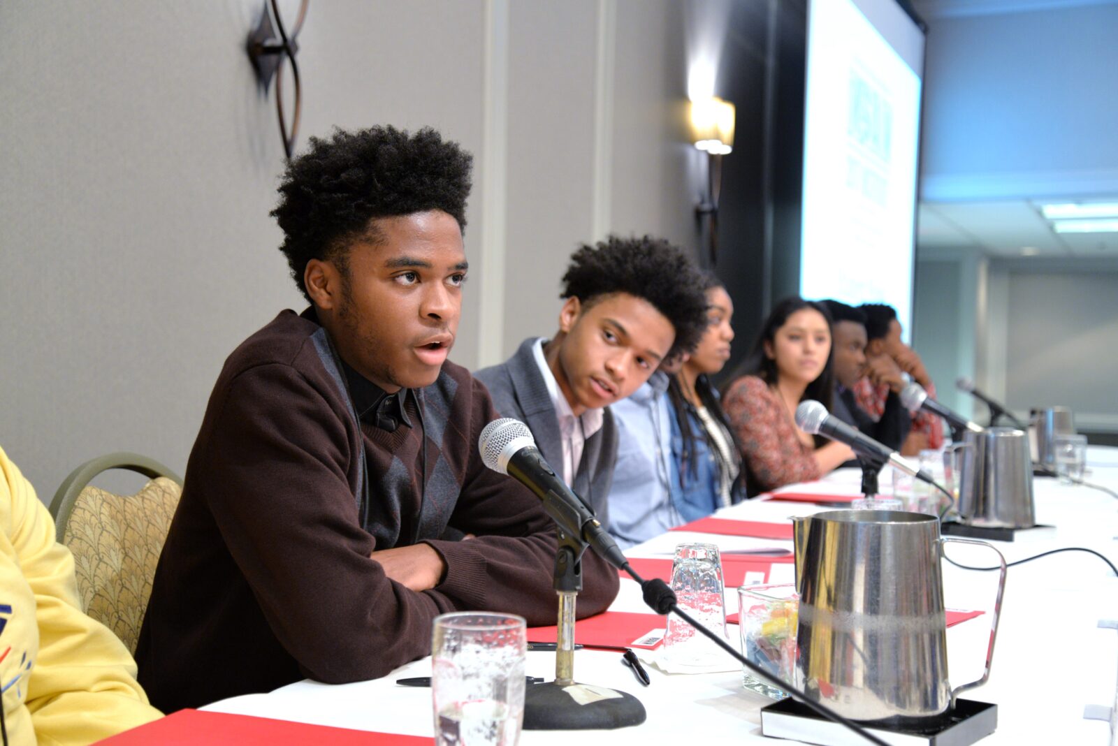 A student speaks into a microphone during a panel at the MSAN Institute.